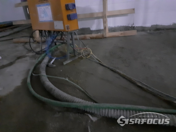 건물바닥에 물이 흥건하게 적셔있는데도 전선거치대조차 없는 상태에서 버젓이 노출된 물젖은 전선들. 안전불감증이 여전하다. 사진 / 이현승 기자