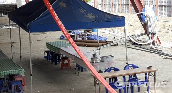 복컴 인부들의 열악한 근로환경, 임시로 천막을 친 허름하고 먼지투성이 야외식당에서 점심을 해결하고, 차디찬 시멘트바다에서 누워 휴식을 취한다. 사진 / 이현승 기자.