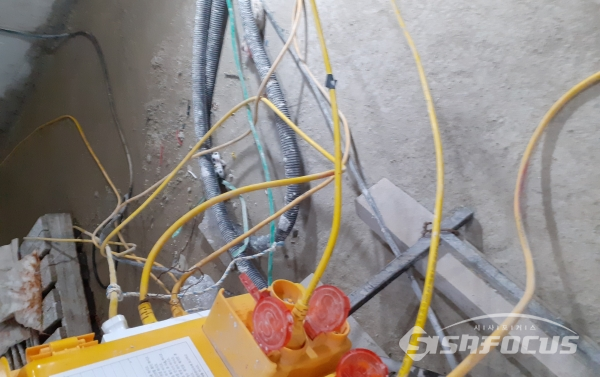 배전함에서 이어진 여러 가닥의 전기선들이 흥건하게 배인 시멘트바닥에 나뒹굴고 있다. 거치대조차 없어 심각한 안전 불감증을 보여주고 있다. 사진 / 이현승 기자