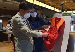 나경수 SK종합화학사장이 폐플라스틱 활용 원단으로 만든 봉사 조끼를 살표보고 있다. ⓒSK이노베이션​