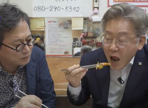 이재명 경기도지사가 쿠팡 물류센터 화재 당시 황교익 씨(좌)의 유튜브에 출연해 창원에서 함께 떡볶이 먹방을 하고 있다. ⓒ황교익TV