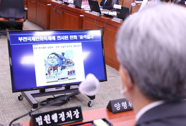 4일 시작된 국회 법제사법위원회 국정감사장에서 한 고등학생이 그린 풍자만화 '윤석열차'가 등장해 '표현의 자유'에 대한 논쟁이 벌어졌다. 사진은 김상환 법원행정처장이 해당 작품을 보고 있는 모습. 사진 / ⓒ뉴시스