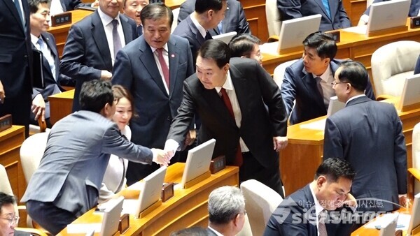 윤석열 대통령이 내년도 예산안 관련 시정연설을 하기 위해 31일 국회 본회의장에 입장한 뒤 의원들과 악수하고 있다. 사진 / 박상민 기자