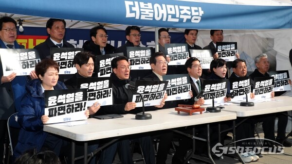 19일 서울 종로구 광화문 민주당 천막농성장에서 열린 더불어민주당 현장 최고위원회의에서 이재명 대표를 비롯해 박찬대 원내대표, 최고위원들이 손피켓을 들고 구호를 외치고 있다. 사진 / 오훈 기자